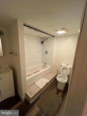 a bathroom with a granite countertop bathtub shower and toilet