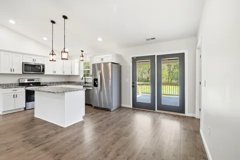 a kitchen with stainless steel appliances a refrigerator and wooden floor