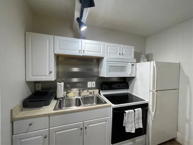 a kitchen with a refrigerator sink and cabinets