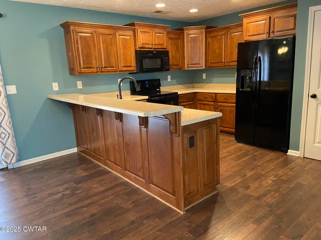 a kitchen with stainless steel appliances granite countertop a refrigerator a sink and a stove