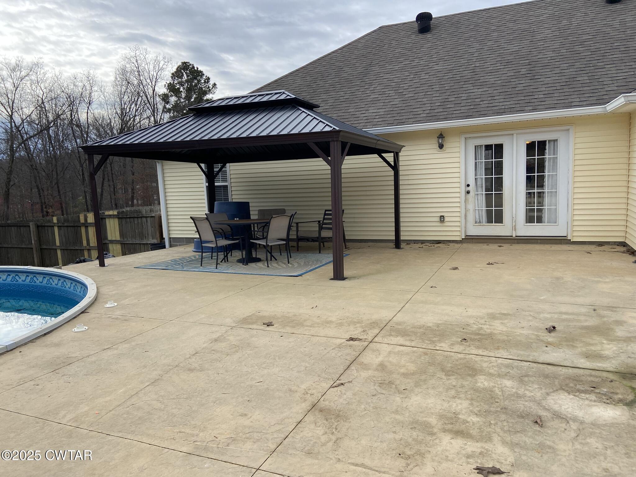 90 Timber Ridge Cove Henderson, TN 38340 - Photo 3 of 30 a view of a patio with table and chairs under an umbrella with a barbeque