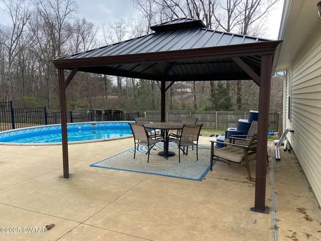 a view of patio with table and chairs under an umbrella