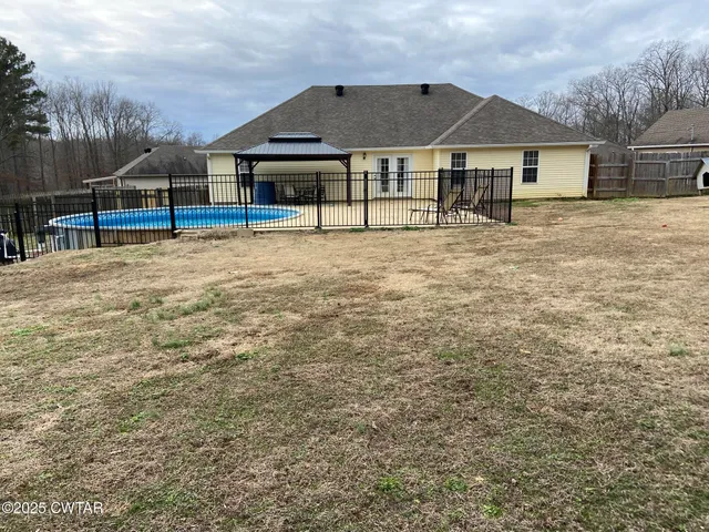 a view of a house with wooden deck and a big yard