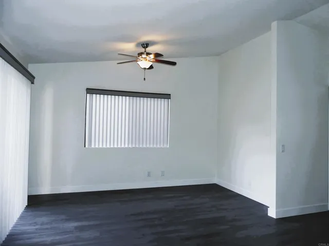 a view of a hallway with a room and wooden floor