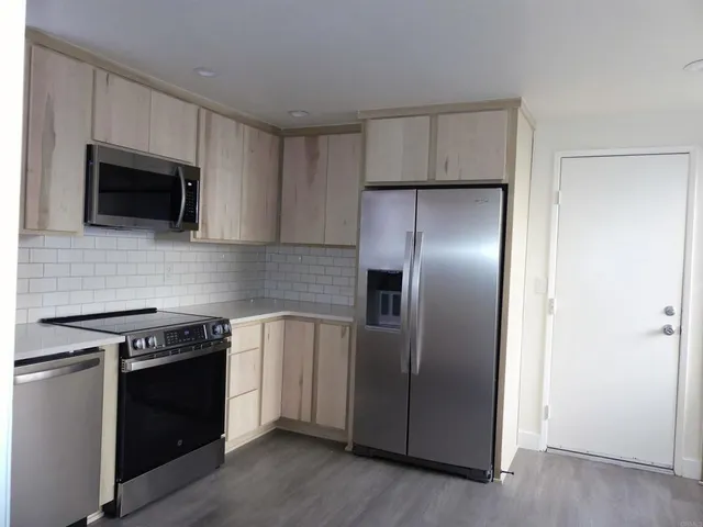 a kitchen with a stainless steel appliances wooden cabinets and a stove top oven