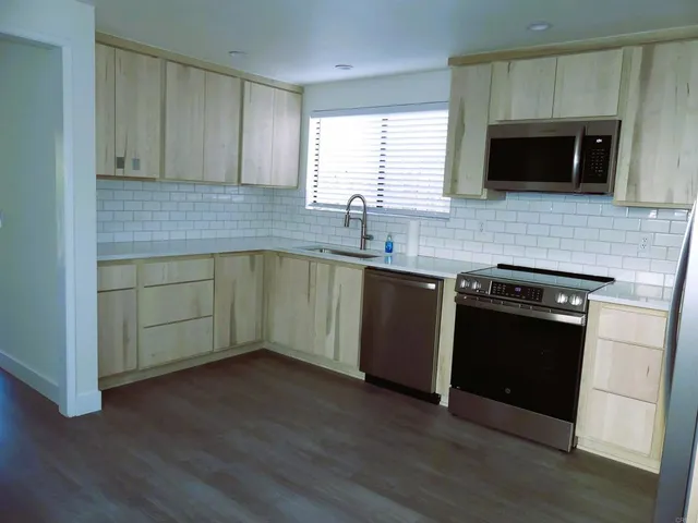 a kitchen with stainless steel appliances a stove a sink and a microwave