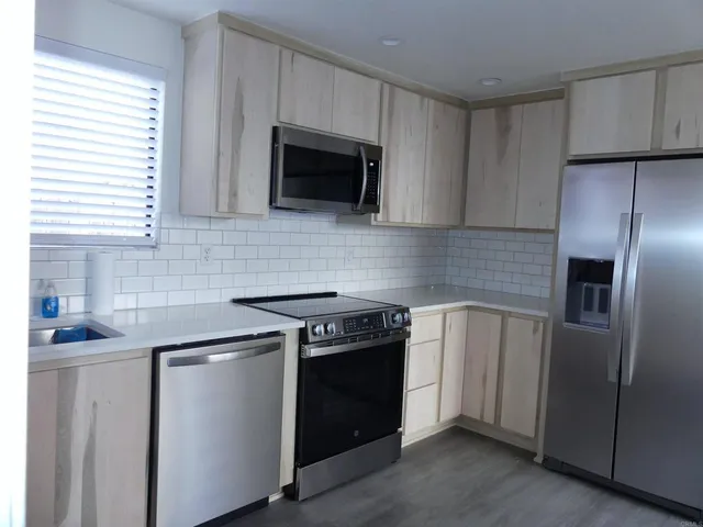 a kitchen with stainless steel appliances a stove a microwave and a sink