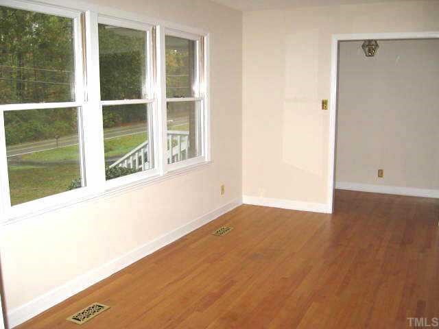 Beautiful living room with three windows & hardwoods