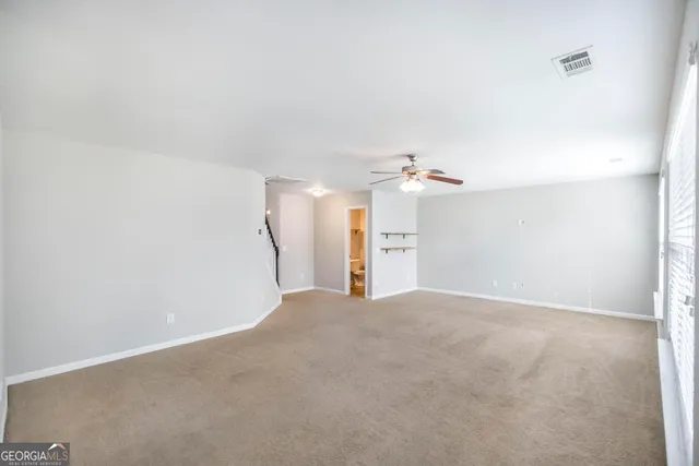 a view of a big room with cabinet and a ceiling fan
