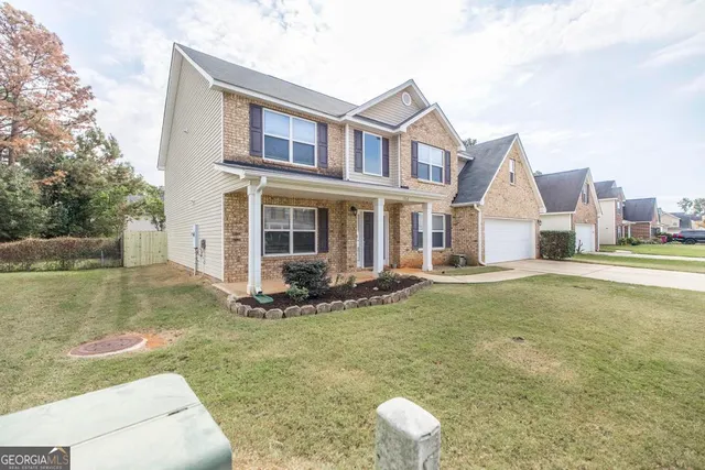 a view of a house with a yard and sitting area