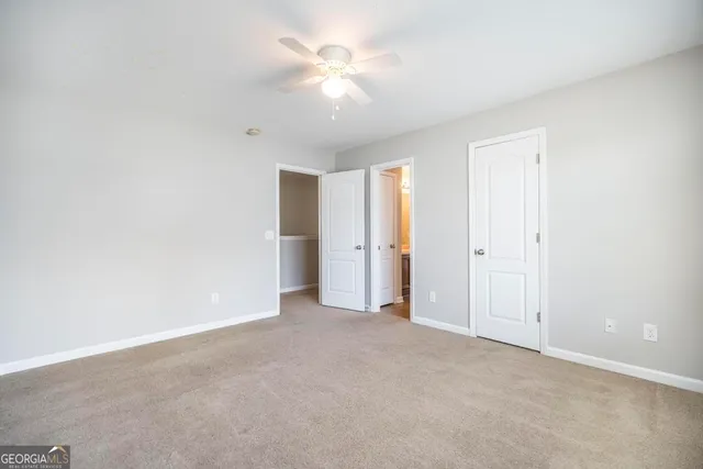 an empty room with a ceiling fan and a window