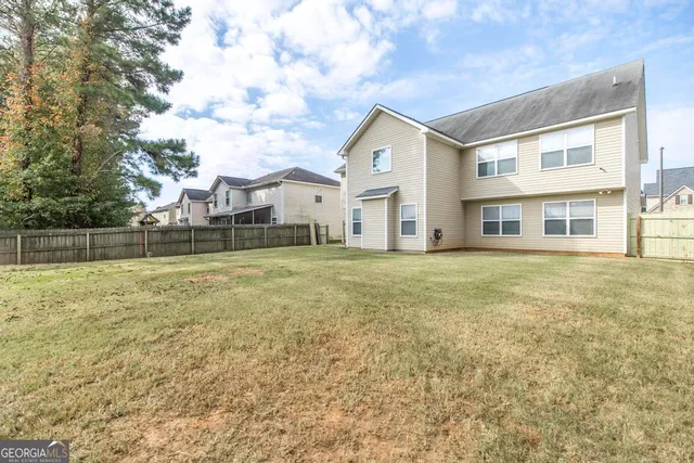 a view of a white house with a big yard and large trees