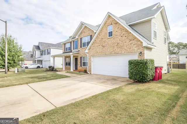 a view of an house with backyard and road
