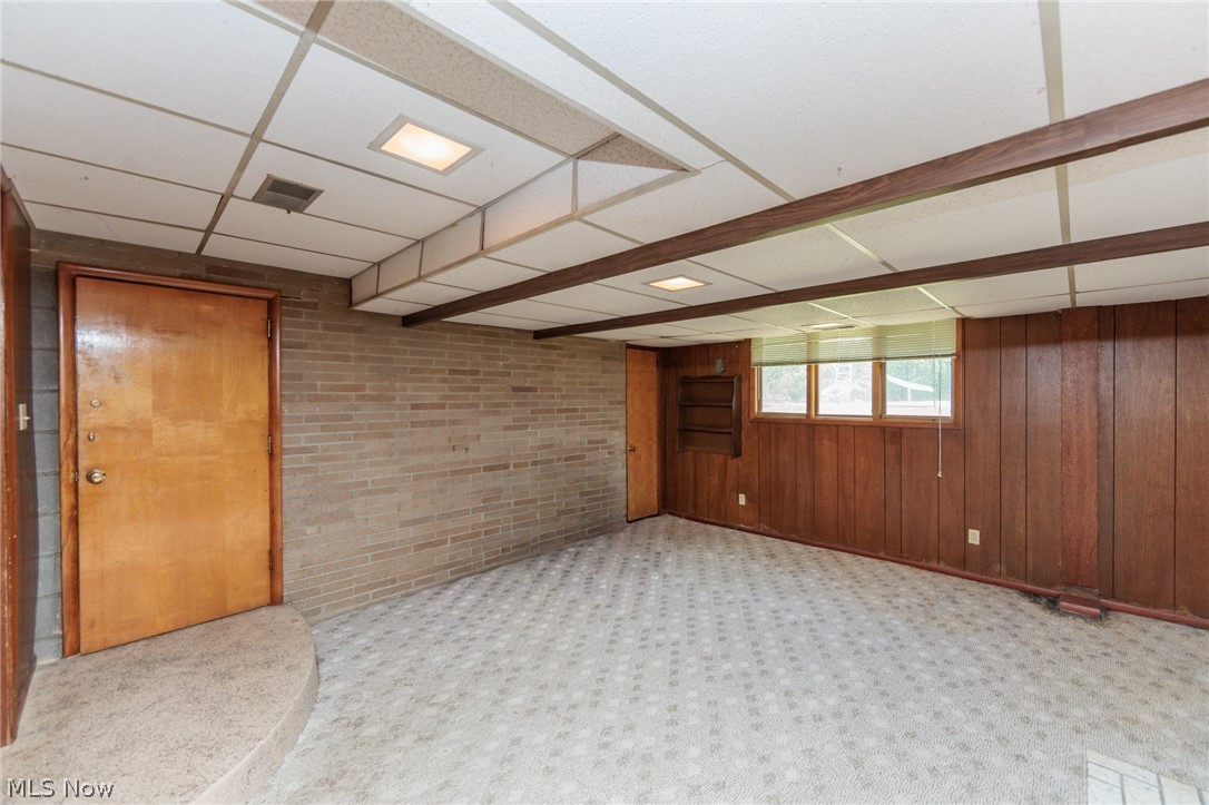 2170 Norton Road Stow, OH 44224 - Photo 44 of 48 Interior space featuring a drop ceiling with integrated lighting, wood-paneled walls, and a patterned carpet