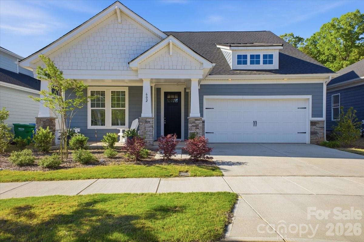 a front view of a house with a yard outdoor seating and garage