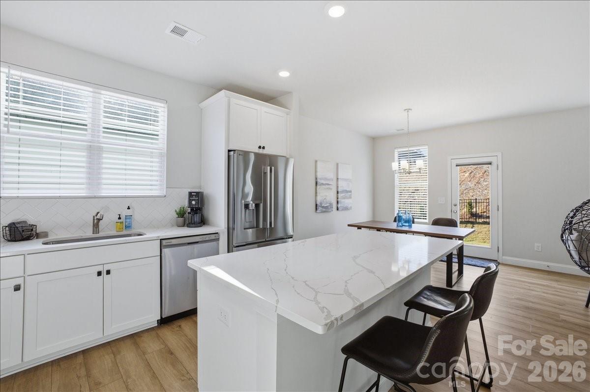 602 Banter Lane Cramerton, NC 28056 - Photo 6 of 33 a kitchen with stainless steel appliances a dining table chairs and wooden floor