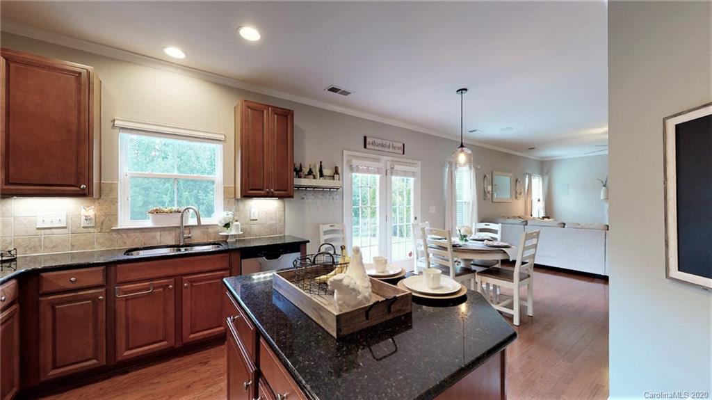 3010 Fallondale Road Waxhaw, NC 28173 - Photo 20 of 44 a kitchen with a stove a sink dishwasher a dining table and chairs with wooden floor