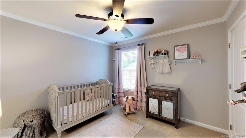 3010 Fallondale Road Waxhaw, NC 28173 - Photo 29 of 44 a bedroom with a bed and a chandelier