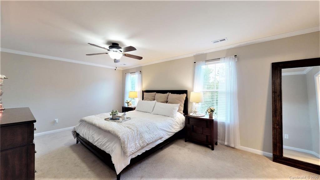 3010 Fallondale Road Waxhaw, NC 28173 - Photo 31 of 44 a bedroom with bed and a chandelier