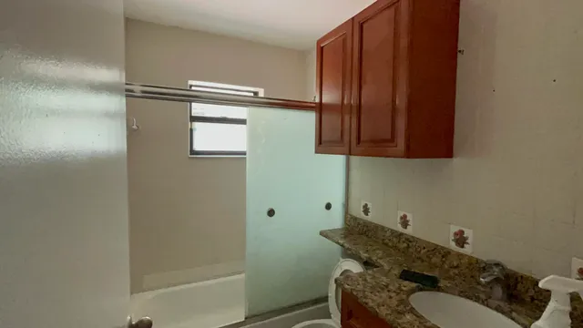 a bathroom with a granite countertop sink and a mirror