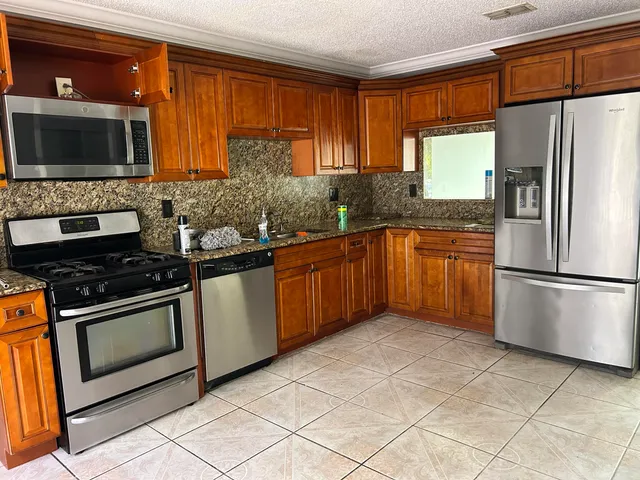 a kitchen with stainless steel appliances a stove a sink and a microwave