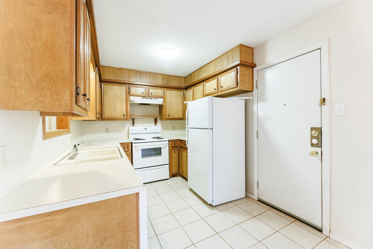 5809 Emory Street Lubbock, TX 79416 - Photo 14 of 30 a kitchen with a refrigerator sink stove and cabinets