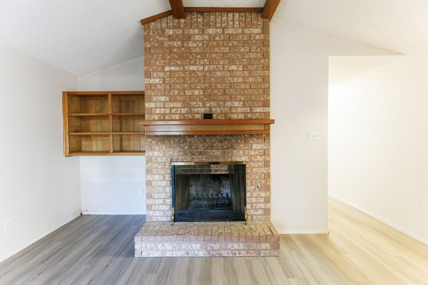 5809 Emory Street Lubbock, TX 79416 - Photo 8 of 30 a living room with a fireplace and a wooden floor