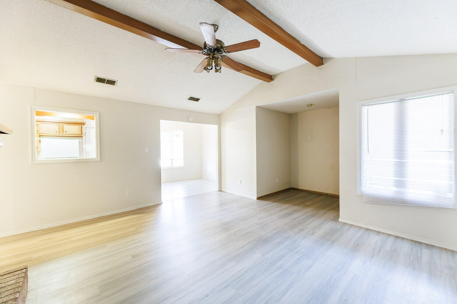 5809 Emory Street Lubbock, TX 79416 - Photo 9 of 30 an empty room with wooden floor fan and windows