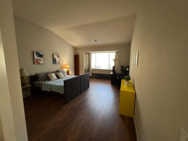a living room with furniture and a wooden floor