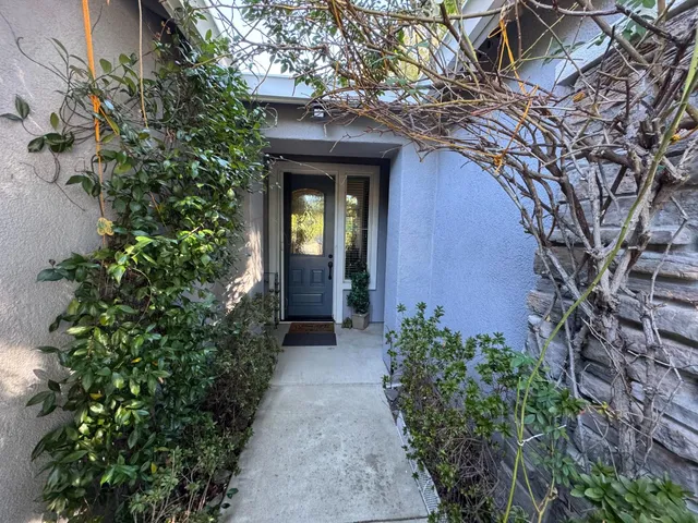 an entrance to house with yard and green space
