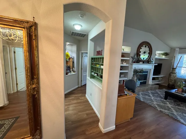 a view of a hallway with wooden floor fireplace and dining room