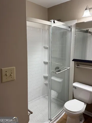 a bathroom with a toilet and a shower