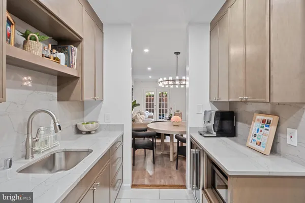 a kitchen with stainless steel appliances granite countertop a sink a stove and chairs with wooden floor