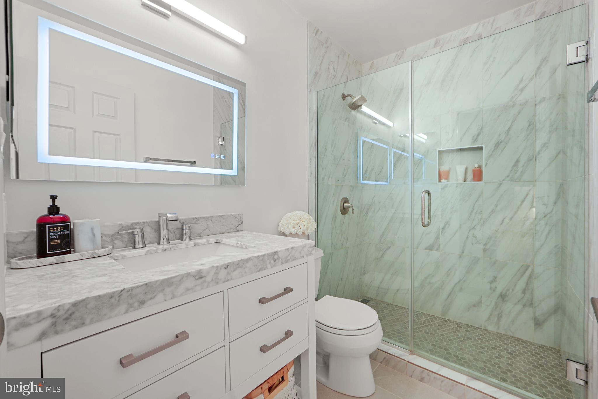 4311 Massachusetts Avenue Northwest Washington, DC 20016 - Photo 8 of 30 Sleek marble bathroom with modern elegance.