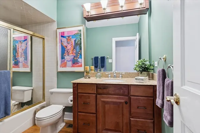 a bathroom with a granite countertop toilet a sink and a mirror