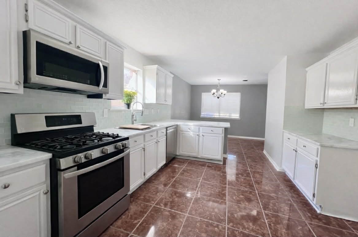 19514 Azalea Valley Drive Katy, TX 77449 - Photo 5 of 28 a kitchen with stainless steel appliances a sink dishwasher stove top oven and cabinets