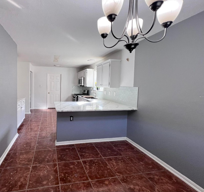 19514 Azalea Valley Drive Katy, TX 77449 - Photo 7 of 28 a kitchen with stainless steel appliances a counter space cabinets and a chandelier