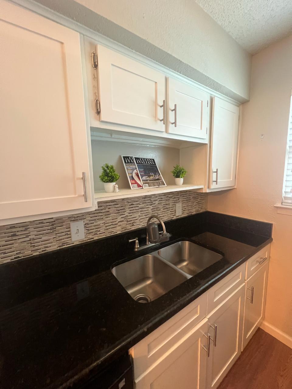 2401 Manor St Road, Unit 118 Austin, TX 78722 - Photo 11 of 17 a kitchen with granite countertop a sink and a stove