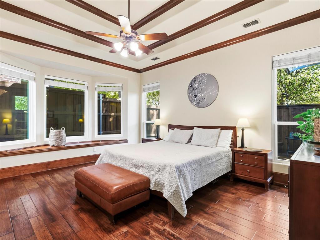 1615 Roma Lane Allen, TX 75013 - Photo 13 of 36 Wood-finish flooring throughout featuring a bay window with a built-in window seat, tray ceiling with decorative wood beams, and a ceiling fan with integrated lighting