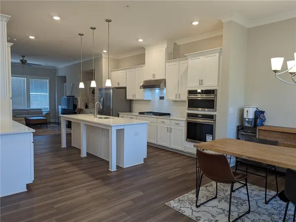 a kitchen with a island in the center and stainless steel appliances
