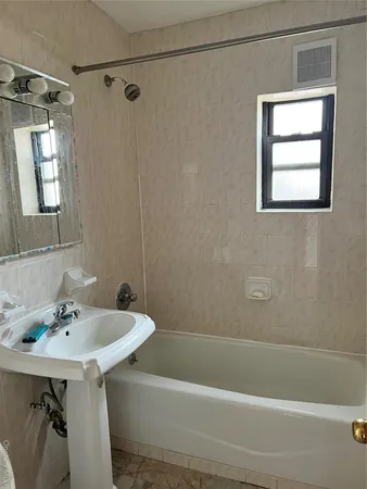 a bathroom with a sink mirror and a bathtub
