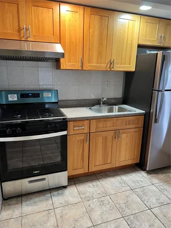 a kitchen with stainless steel appliances a stove a refrigerator and a cabinets