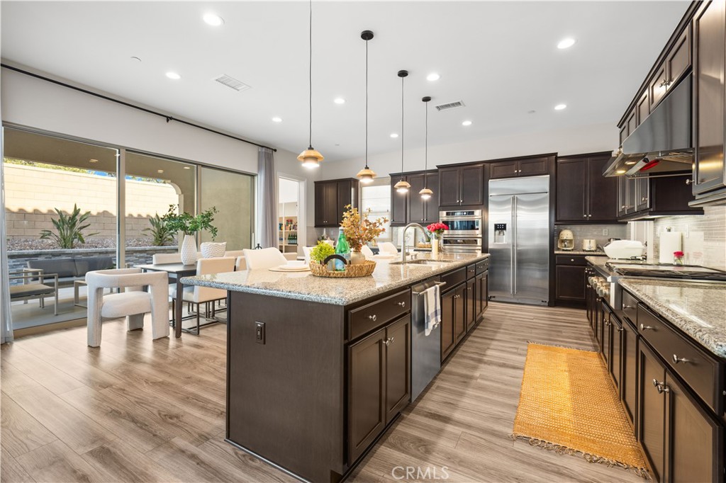 111 Lovelace Irvine, CA 92620 - Photo 11 of 55 a kitchen with kitchen island granite countertop a large center island and a wooden floor