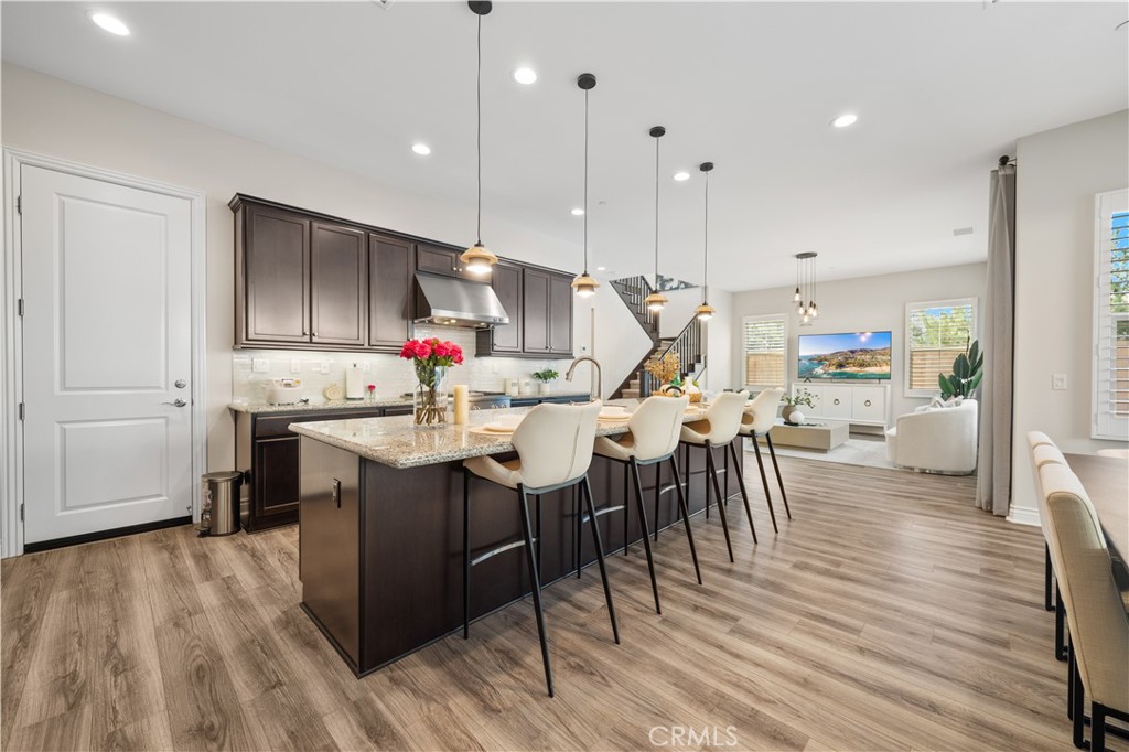 111 Lovelace Irvine, CA 92620 - Photo 12 of 55 a kitchen with stainless steel appliances kitchen island granite countertop a table chairs and a refrigerator