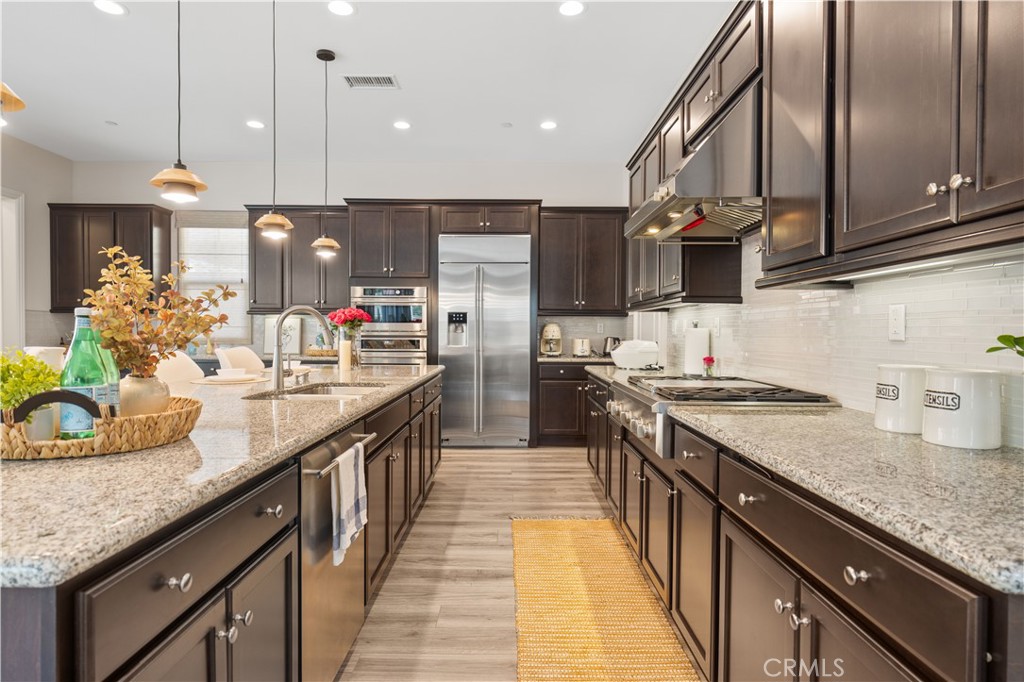 111 Lovelace Irvine, CA 92620 - Photo 17 of 55 a kitchen with stainless steel appliances granite countertop a sink a stove and a wooden floors
