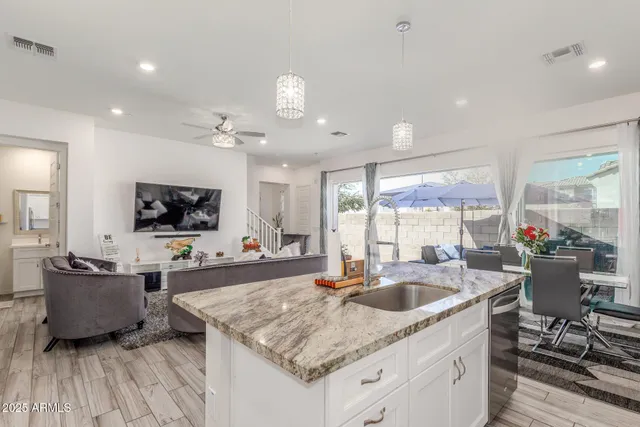a kitchen with a stove a sink a counter space and living room view