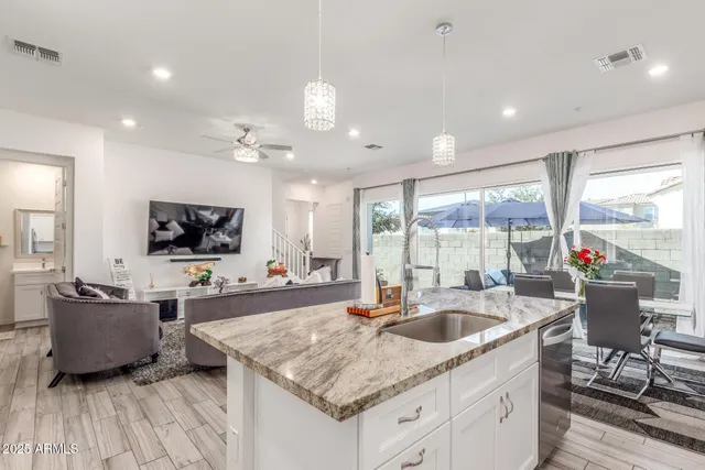 a kitchen with stainless steel appliances kitchen island granite countertop a stove refrigerator and a dining table