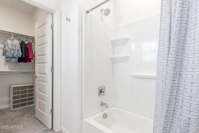 a view of walk in closet with clothes and shoes