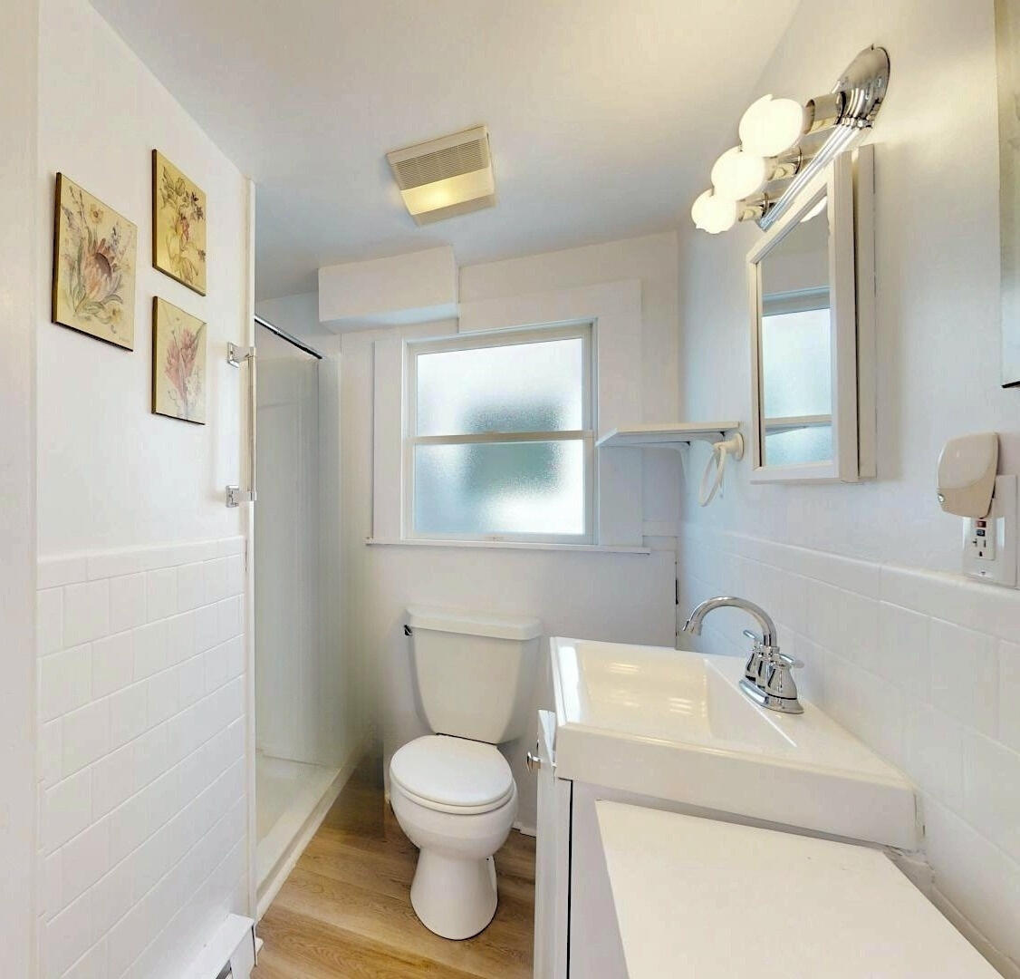 596 Shore Road, Unit G Truro, MA 02666 - Photo 11 of 27 a bathroom with a sink a toilet and a mirror