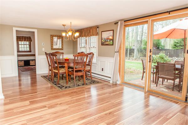 33 Laurel Road Bolton, MA 01740 - Photo 6 of 30 a dining room with wooden floor a chandelier a glass table and chairs